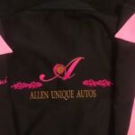 A black jacket with pink lettering and an initial.