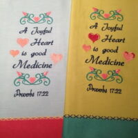 Two towels with a heart and scrolls on them.