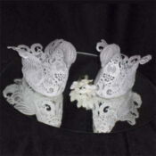 A pair of white lace shoes sitting on top of a mirror.