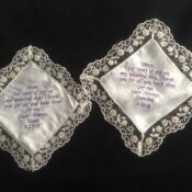 Two white doily with purple writing on them.