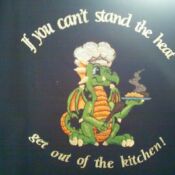 A dragon with a chef hat on and some food in it.