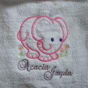A towel with an elephant and name of the baby