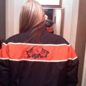 A woman wearing an orange and black jacket.