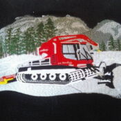 A red snow plow truck is on the side of a mountain.