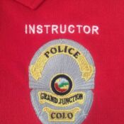 A red polo shirt with the word instructor written on it.