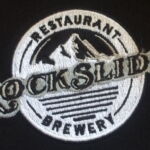 A black and white logo for cock slide restaurant brewery.