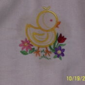 A yellow duck with flowers on it's back.