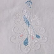 A white cloth with a blue and red peacock on it.