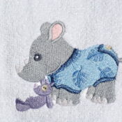 A baby elephant and a teddy bear embroidered on a towel.