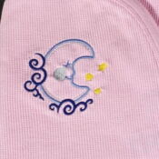 A pink shirt with a blue moon and stars on it.