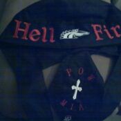A black hat and tie with the words " hell fire " written on it.
