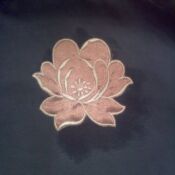 embroidered pink blossom patch on dark fabric