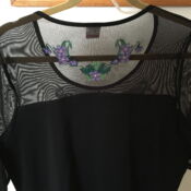 A black dress with a flower patch on the back.