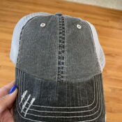 Distressed black denim trucker hat with white mesh