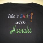Black tee embroidered "Take a Shot with Harrahs