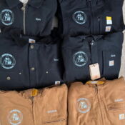 Folded Carhartt work jackets with embroidered patches