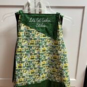 Green embroidered cooking apron hanging on hanger