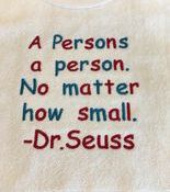 Multicolored embroidered quote on cream fabric