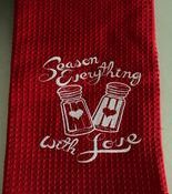 Red kitchen towel reading "Season Everything With Love