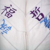 White robes embroidered with purple and blue characters