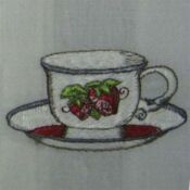 Embroidered teacup and saucer with strawberries