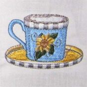 Embroidered blue teacup with yellow flower on saucer