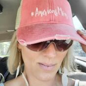 A woman wearing sunglasses and a hat in the car.