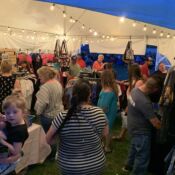 Crowded market tent under string lights